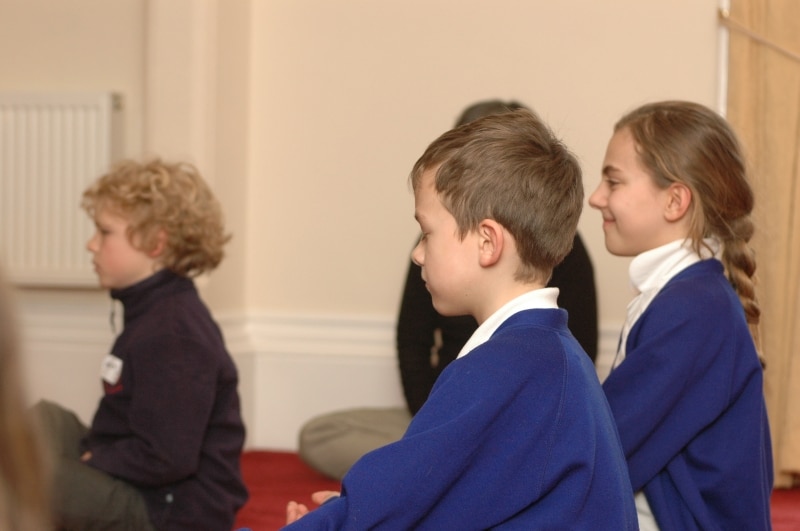 children on a school trip to kmc leeds meditating
